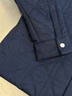 Quilted long jacket hem and side seam with dark navy button