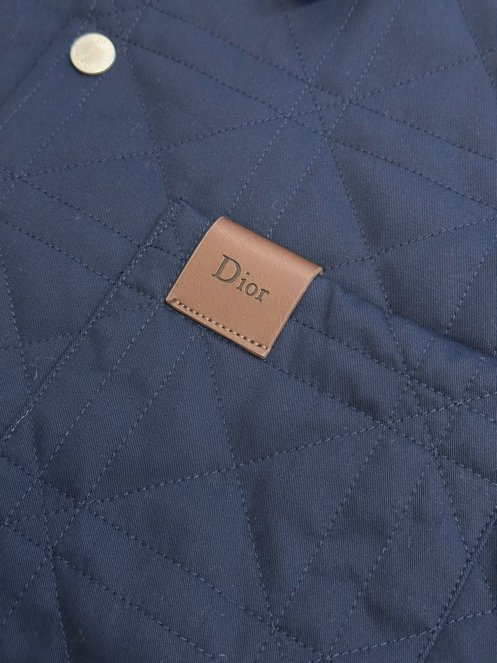 Quilted long jacket fabric with brown Dior logo patch on chest