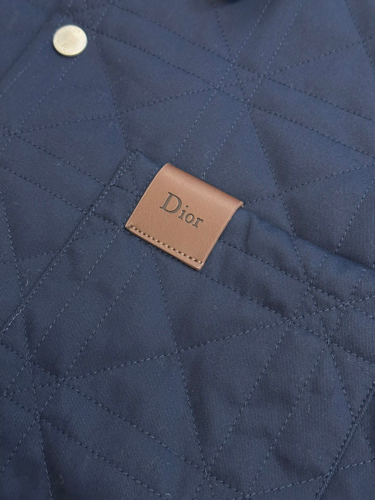 Quilted long jacket fabric with brown Dior logo patch on chest