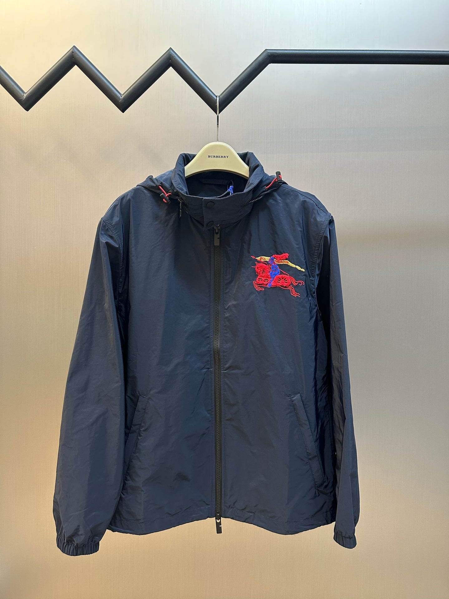Navy zip-up hooded jacket with red and blue crest embroidery