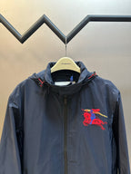 Navy hooded windbreaker jacket with red crest graphic on chest
