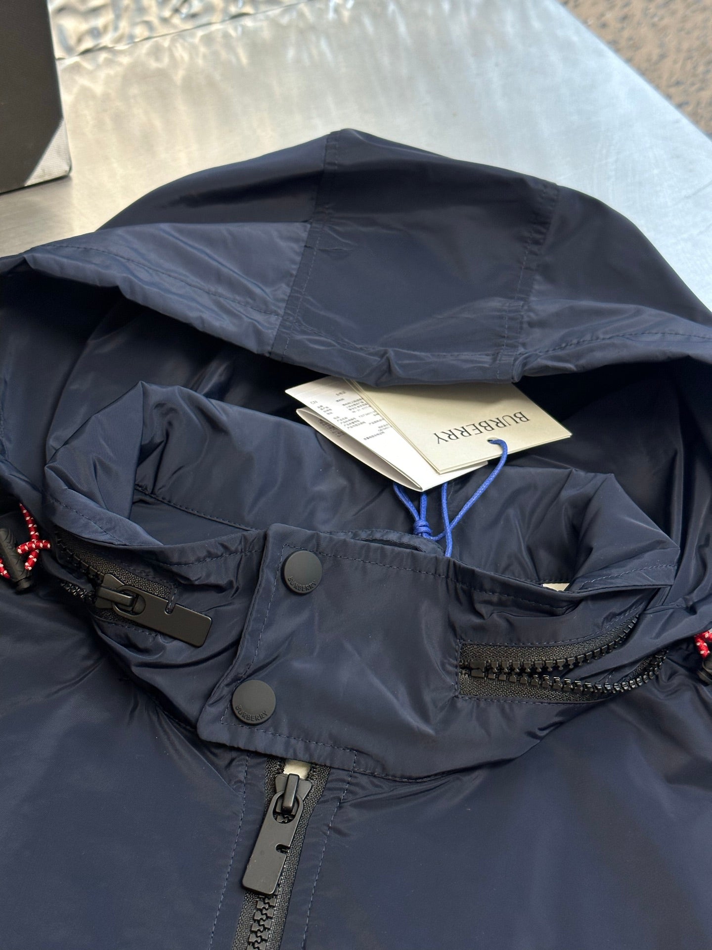 Navy hooded jacket with interior lining and branded hang tag