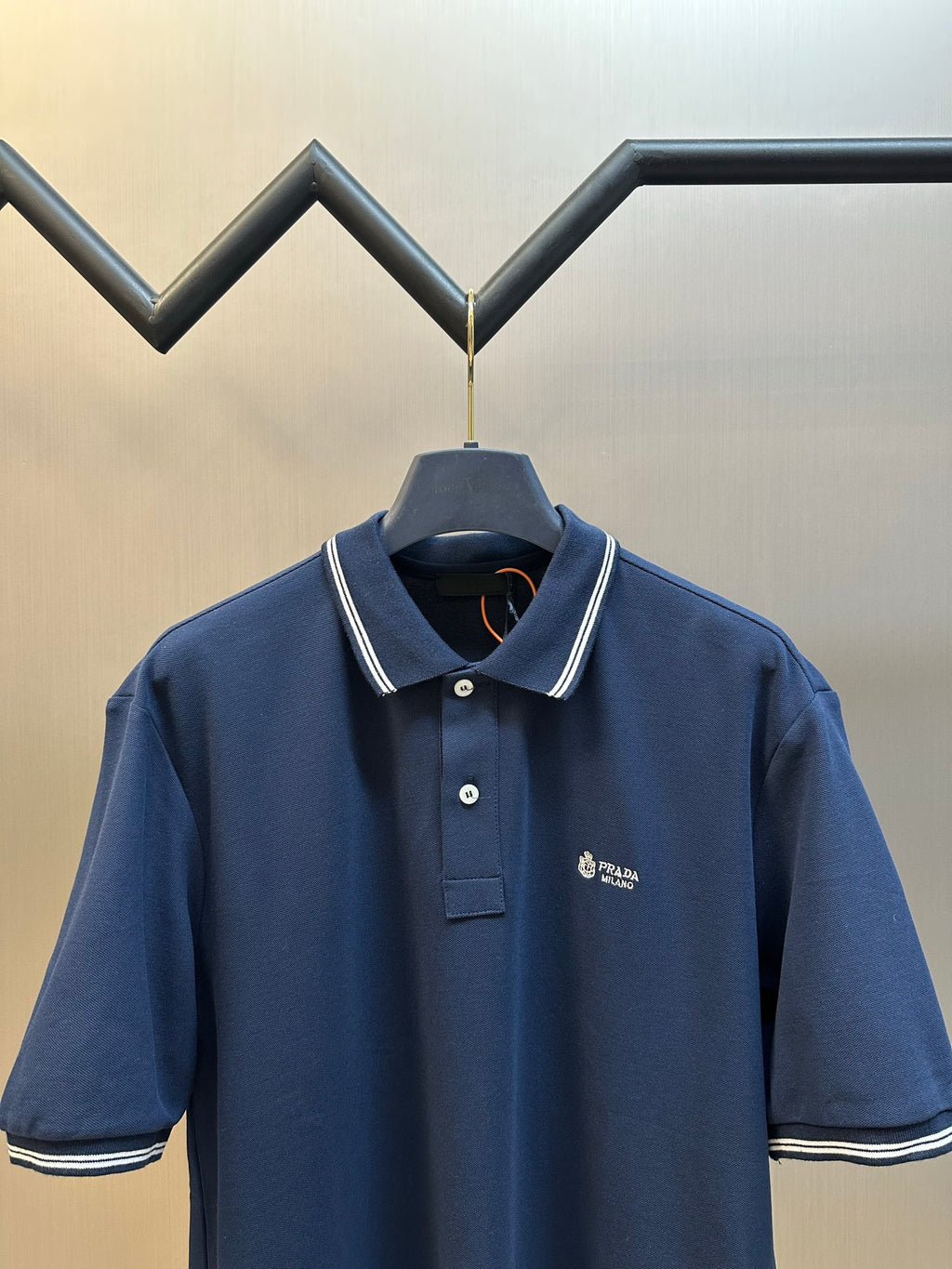 Navy Prada polo shirt front view with chest logo and ribbed collar trim