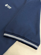 Navy polo shirt hem with contrast striped cuff band
