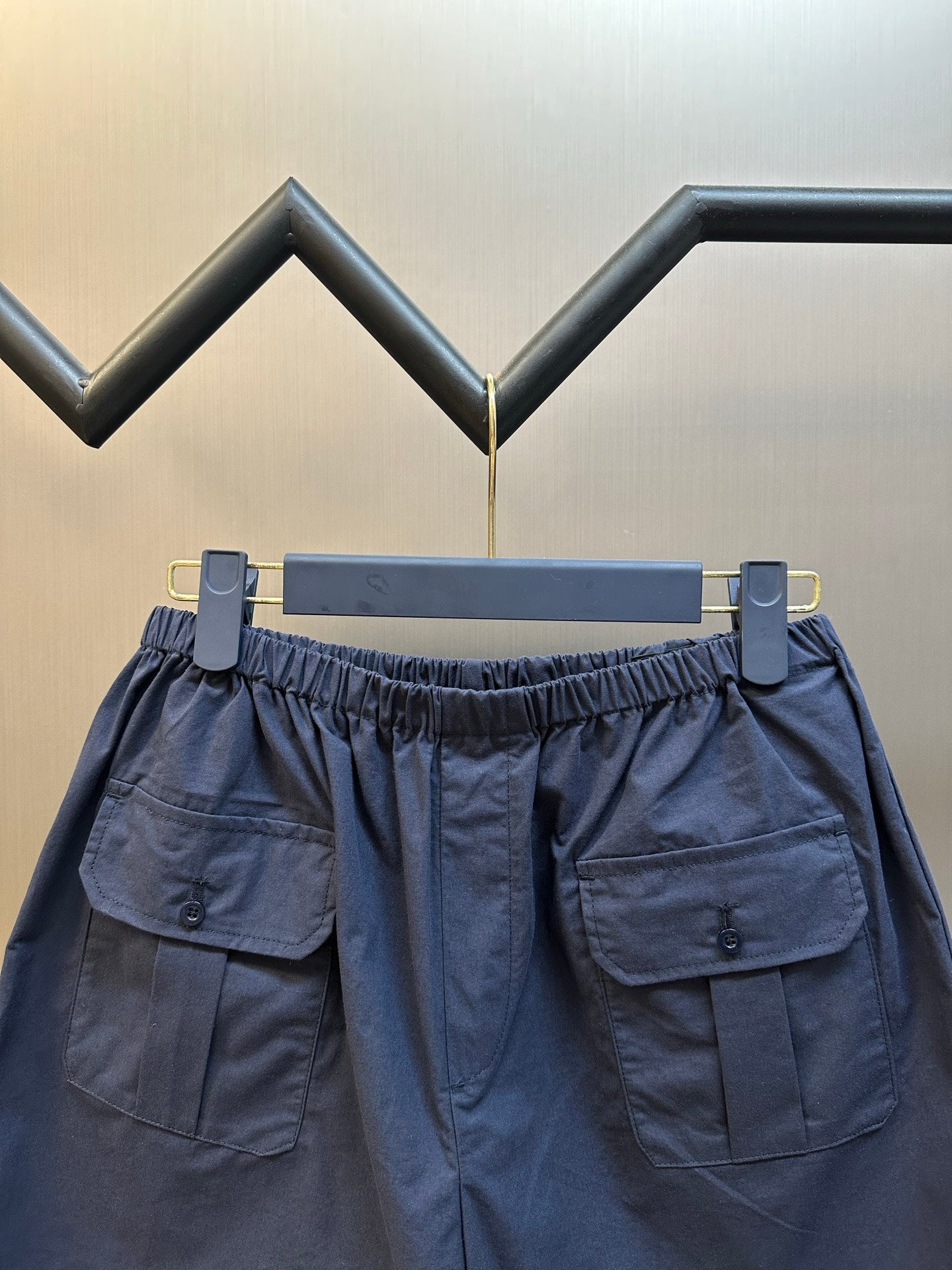 Prada navy shorts with elastic waist, cargo pockets, and button placket