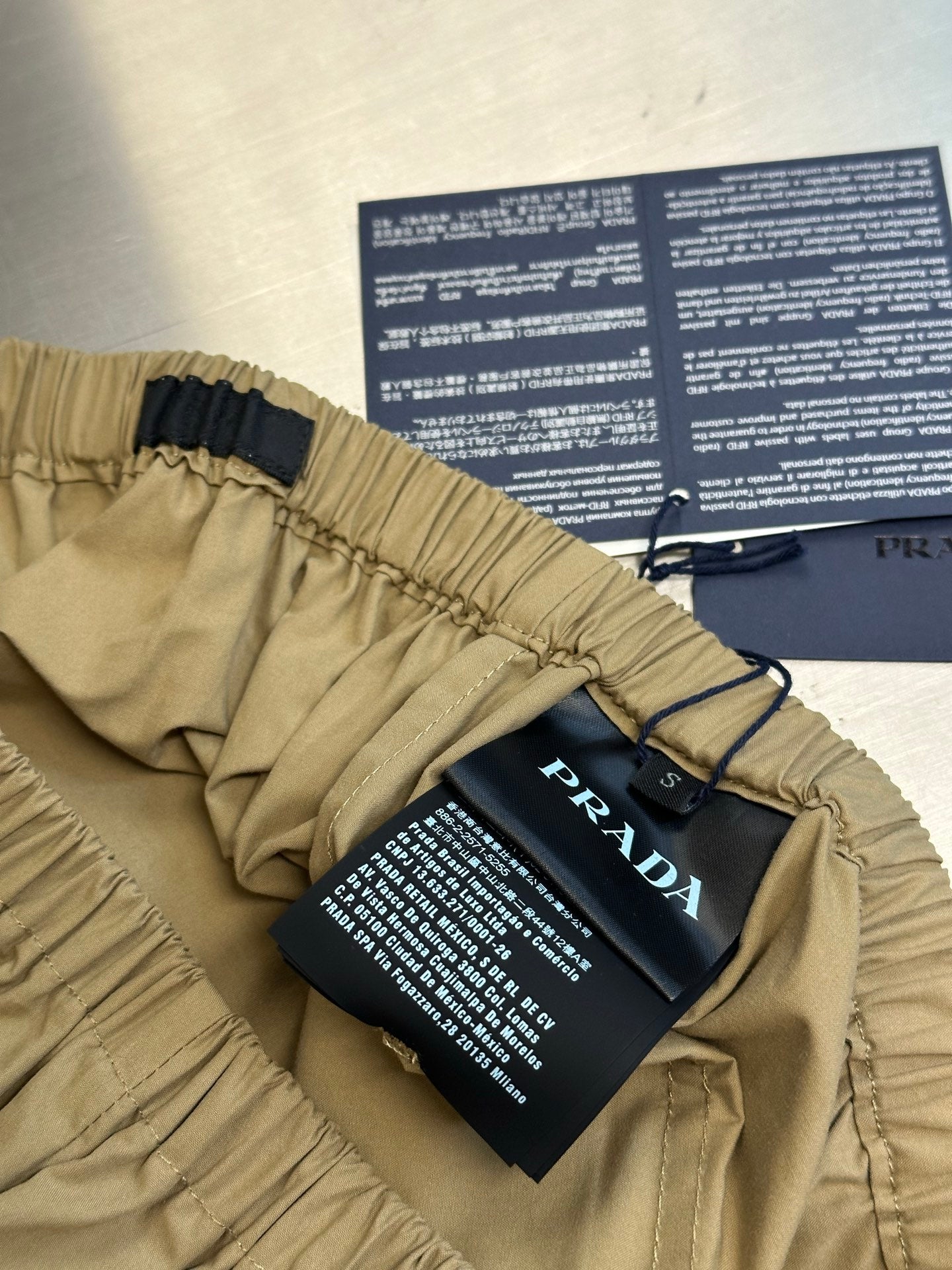 Beige cargo shorts with elastic waistband, belt loops, and hang tags attached.