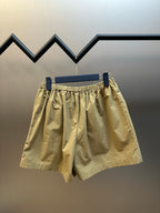 Beige cargo shorts with elastic waistband and relaxed fit, side view on hanger.