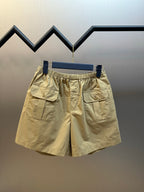 Beige cargo shorts with elastic waistband and front buttoned patch pockets.