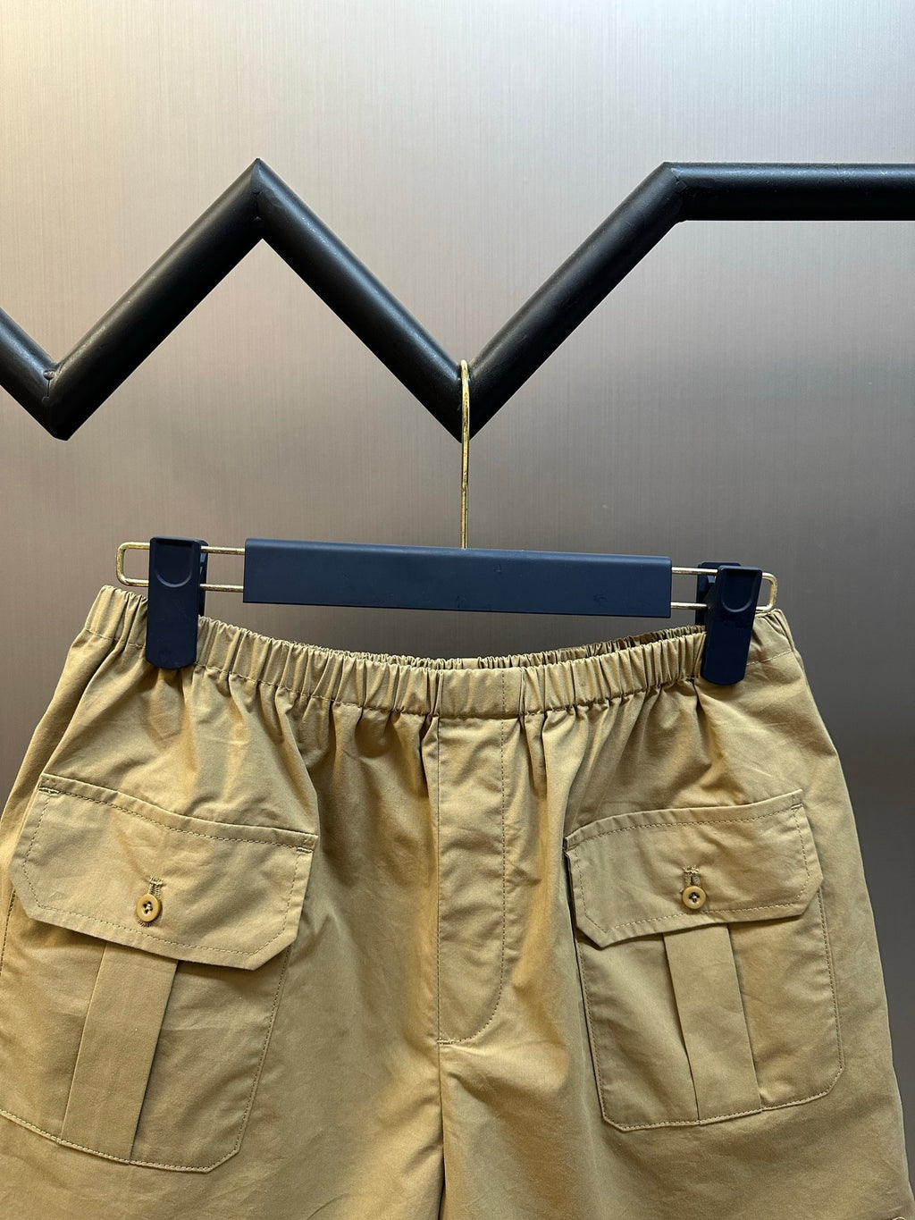 Beige cargo shorts with elastic waistband and dual front patch pockets.