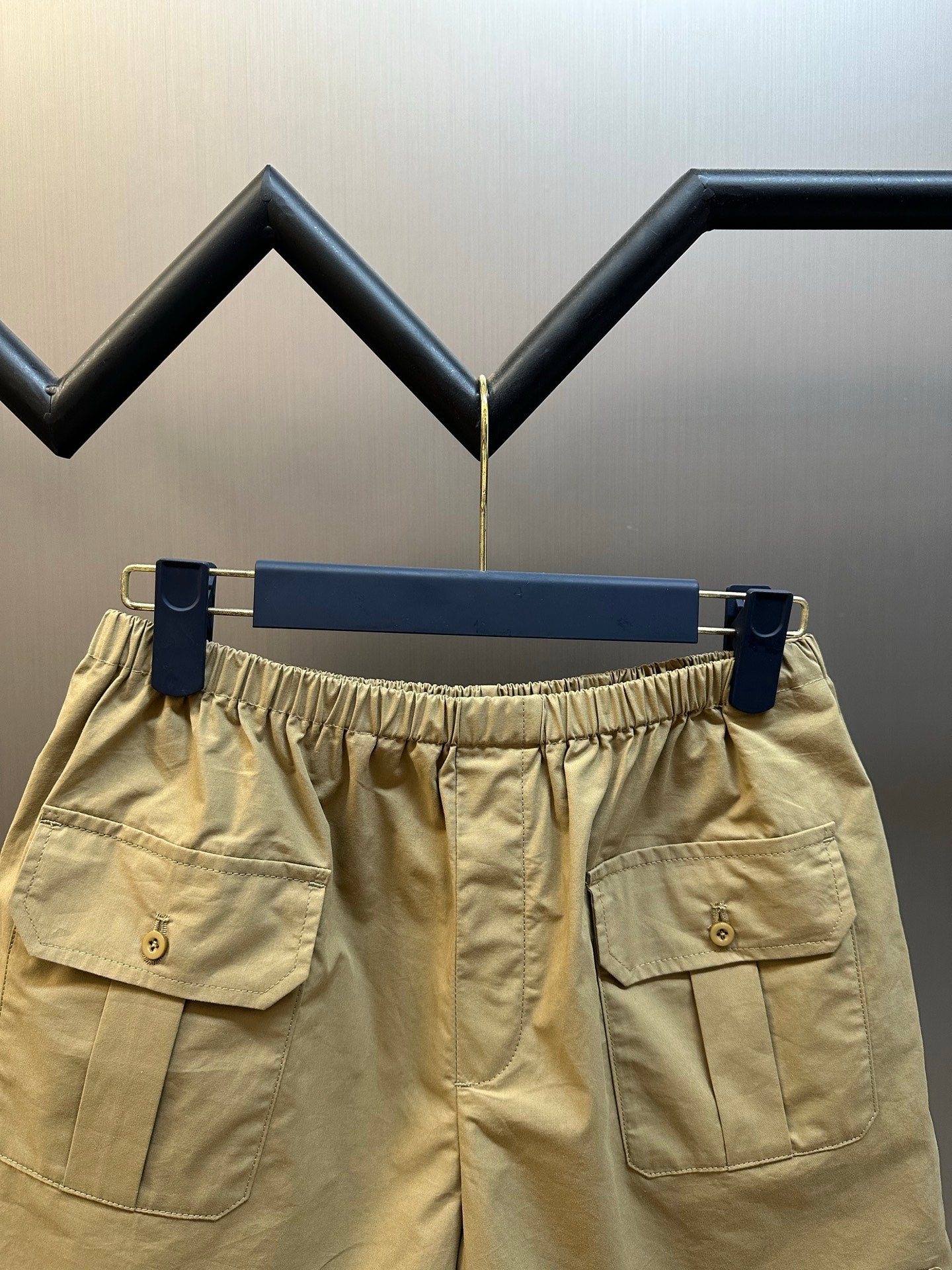Beige cargo shorts with elastic waistband and dual front patch pockets.