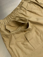 Beige cargo shorts with elastic waistband and front patch pocket detail.
