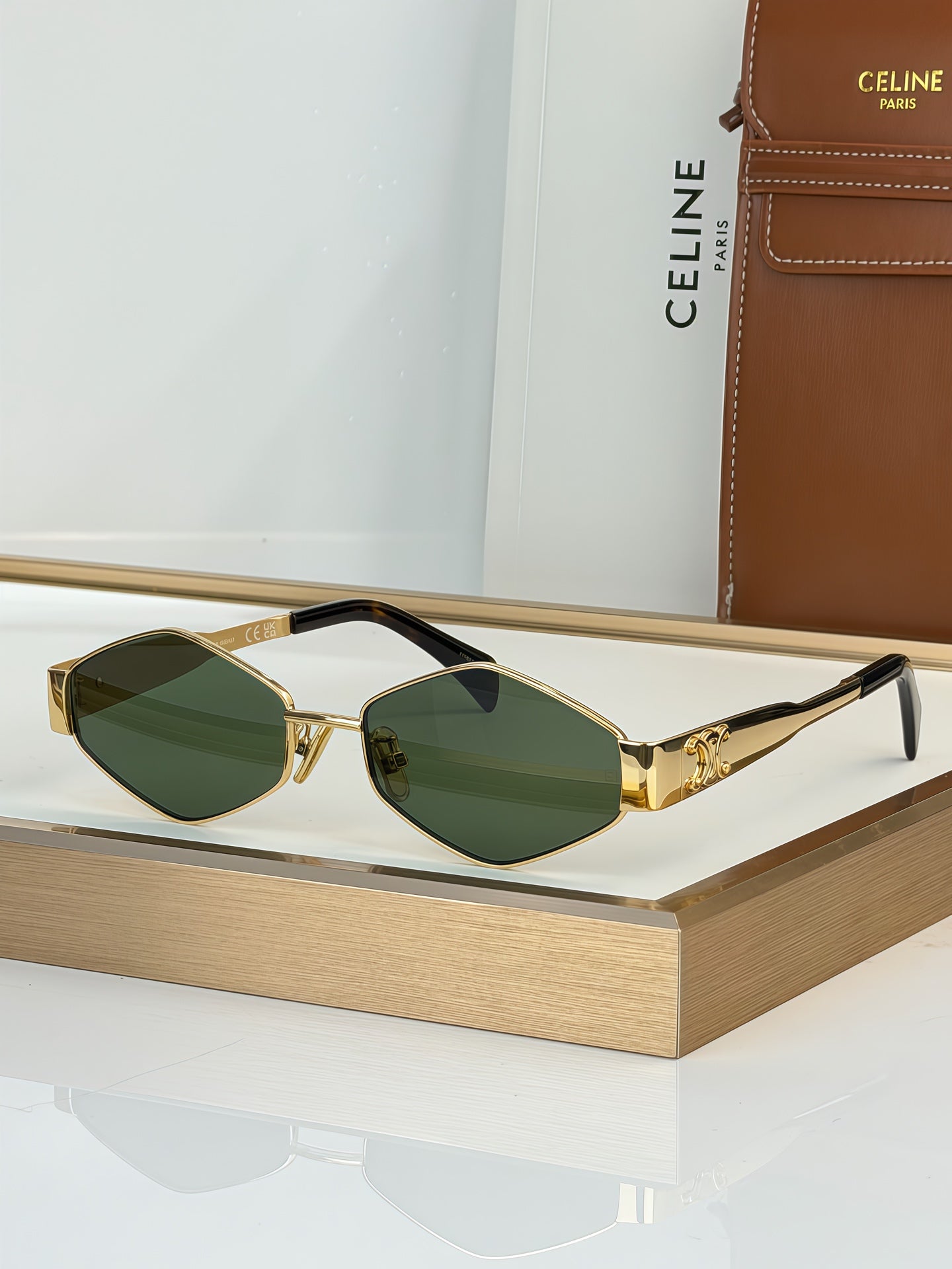 Celine sunglasses with gold-tone frame and green gradient lenses, slim black arms