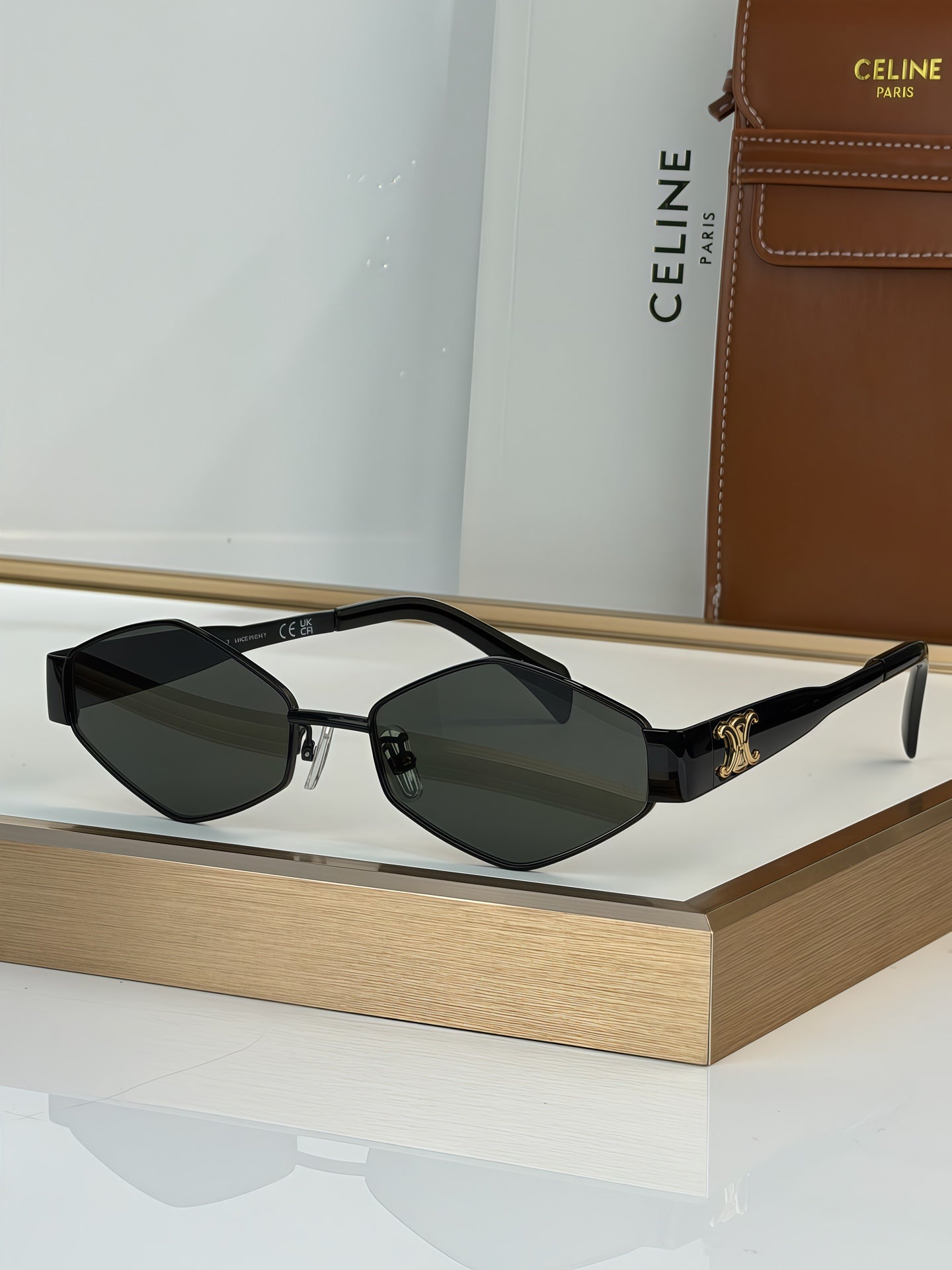 Celine sunglasses with black frame and dark gray lenses, gold-tone accents on arms