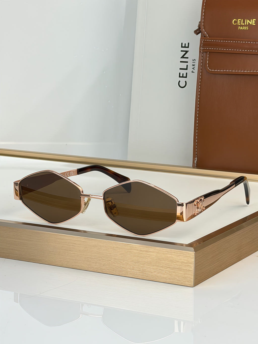 Celine sunglasses with gold-tone frame and dark brown gradient lenses, rose detail arms