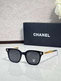 Chanel sunglasses with black round lenses and dark frames, gold logo temple detailing