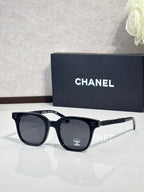 Chanel sunglasses with dark frames, black lenses, and textured black temple detail