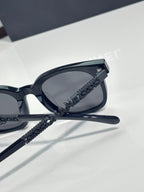 Chanel sunglasses side view with black lens and textured black temple strap detail