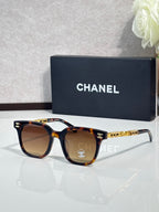 Chanel sunglasses with brown lenses and tortoiseshell frames, gold logo temple accents