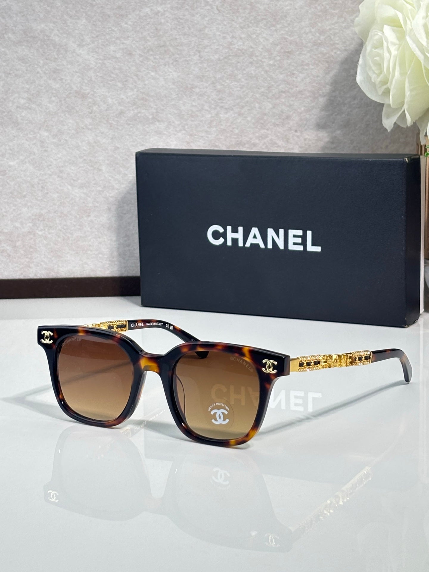 Chanel sunglasses with brown lenses and tortoiseshell frames, gold logo temple accents