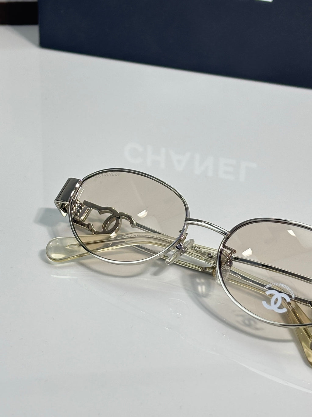 Round eyeglasses with silver metal frame and clear lenses, close-up side view