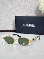 Round sunglasses with gold frame and dark green lenses, gold logo detail on temple