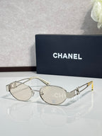 Round sunglasses with silver frame and gray lenses, logo detail on temple