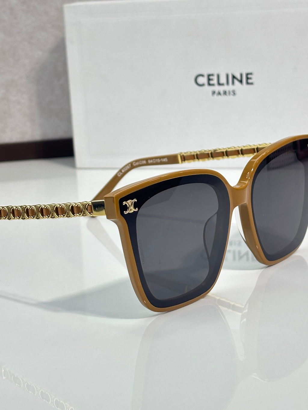 Celine sunglasses side view with gold-tone frame, dark lenses, chain-style temple