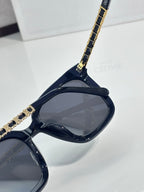 Celine sunglasses close-up of dark lenses and gold chain temple detail