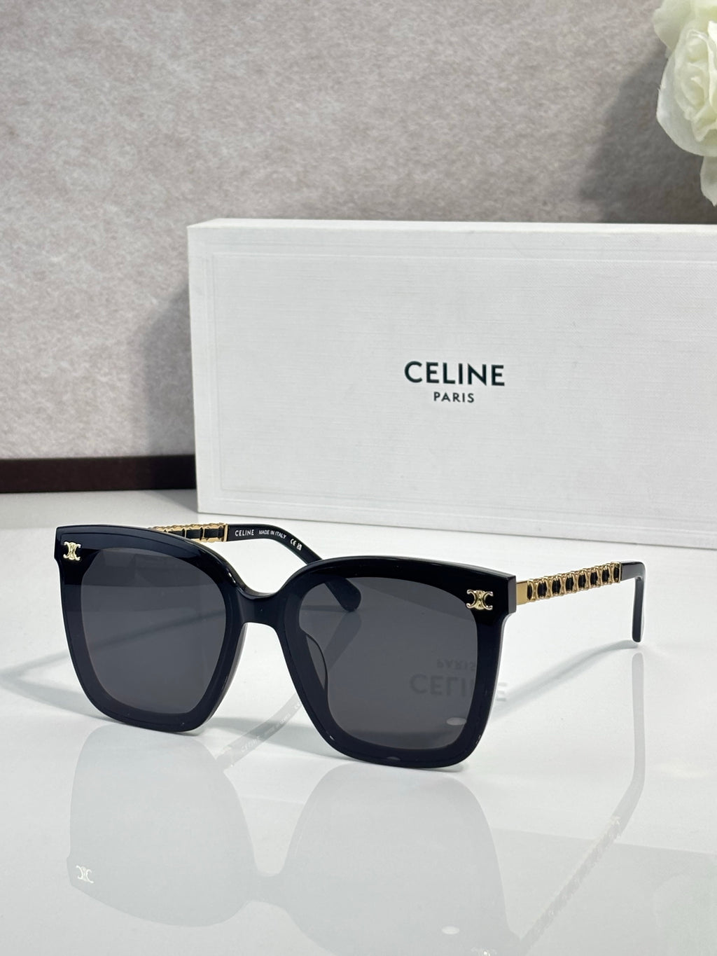 Celine square sunglasses with dark lenses, black frame and gold-tone chain temples