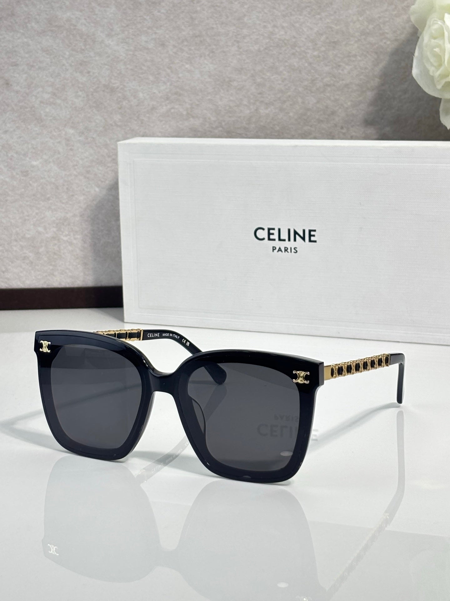 Celine square sunglasses with dark lenses, black frame and gold-tone chain temples