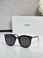 Tortoiseshell sunglasses with dark lenses, gold-tone logo details on the temples