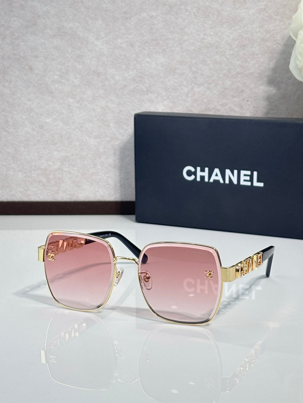 Chanel square sunglasses with pink lenses, gold-tone frame and temple details