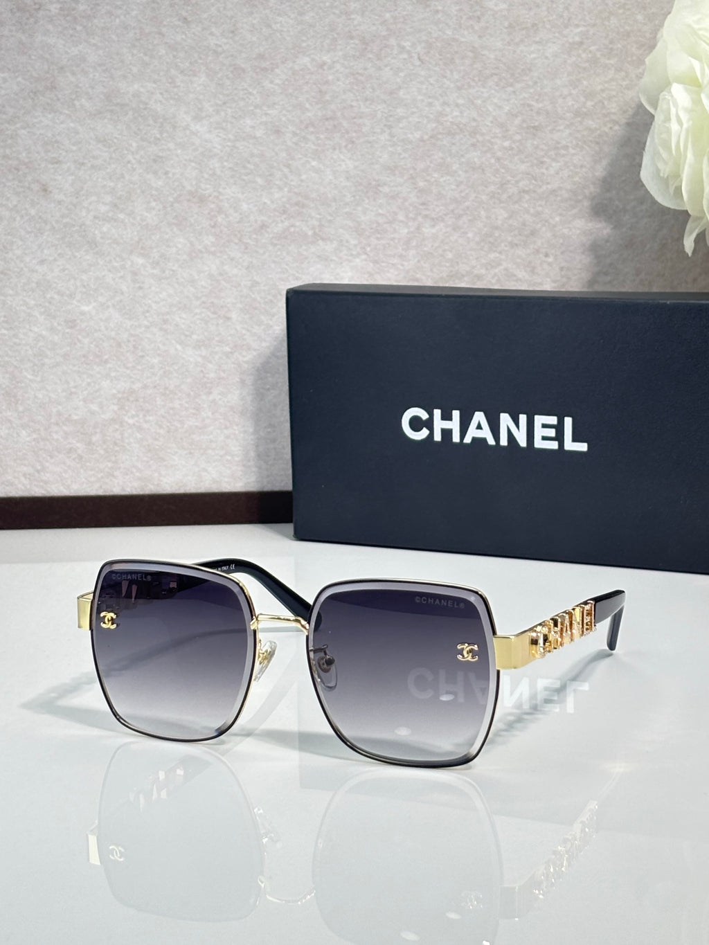 Chanel square sunglasses with smoky lenses, silver frame, gold temple accents