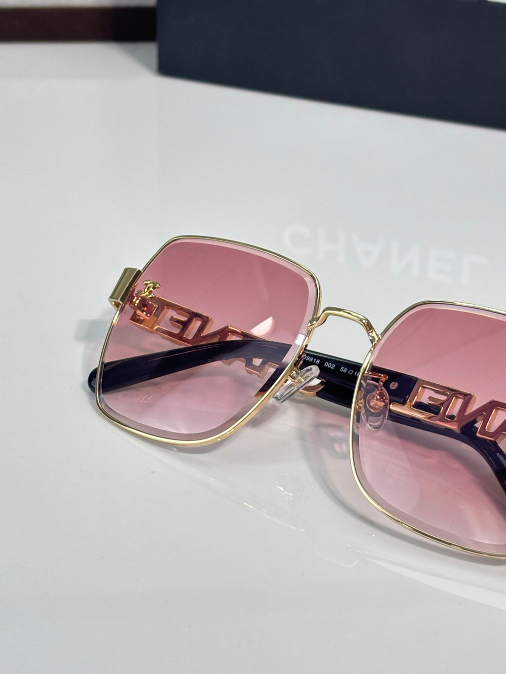 Chanel square sunglasses with pink lenses, rose-tinted frame, gold temple detail