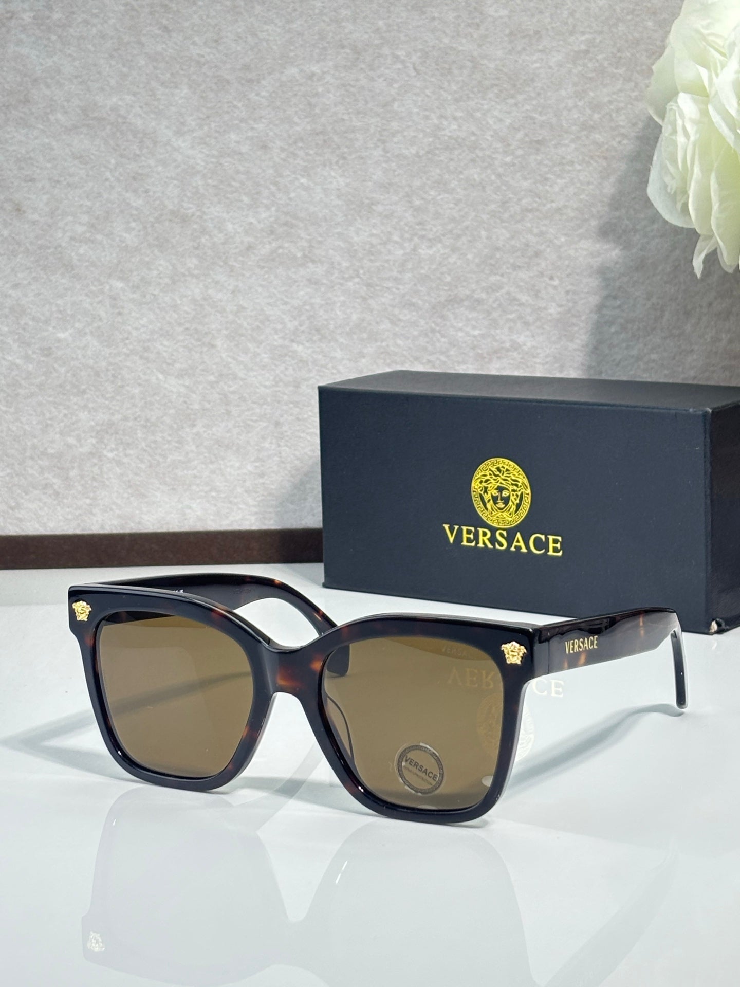 Versace sunglasses with dark brown square frames and smoky lenses, gold emblem on temple