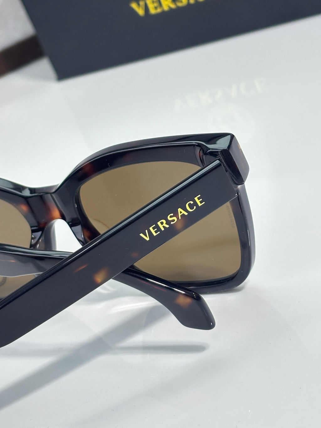 Versace sunglasses with dark tortoiseshell frames and tan lenses, gold VERSACE text on arm