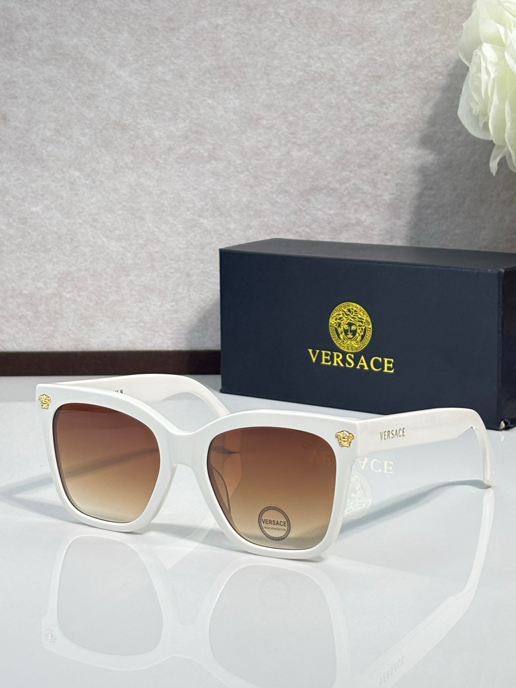 Versace sunglasses with white square frames and brown gradient lenses, gold logo on temple