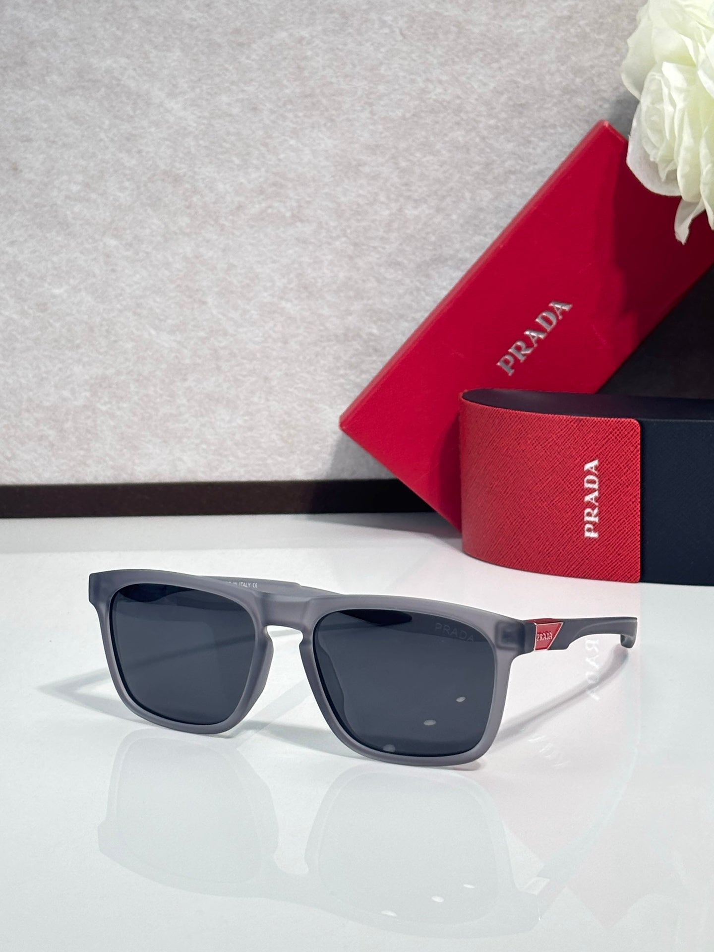 Prada square sunglasses with dark lenses and gray temples, front view