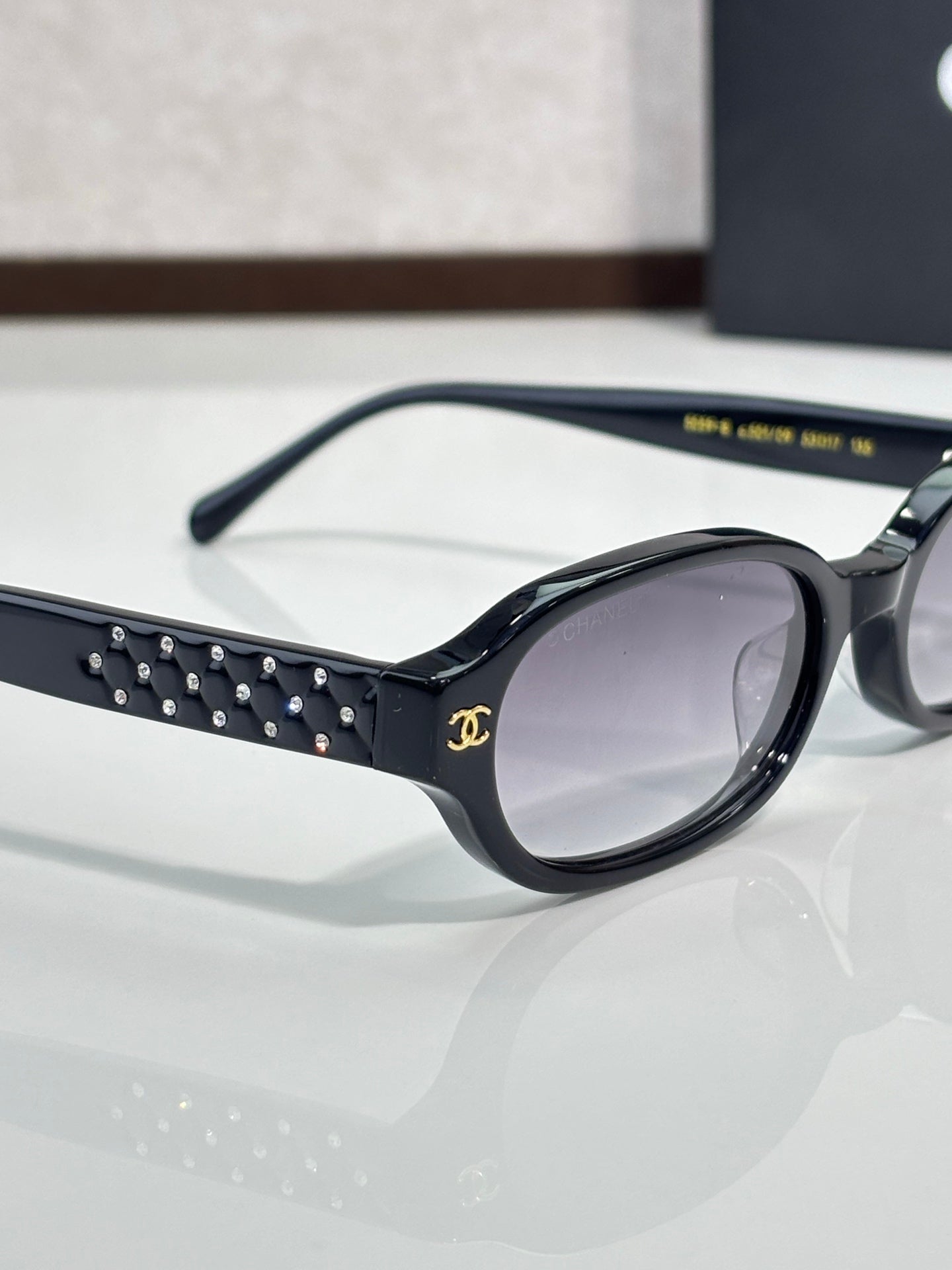 Chanel eyeglasses close-up: black frame with studded temple and clear lens