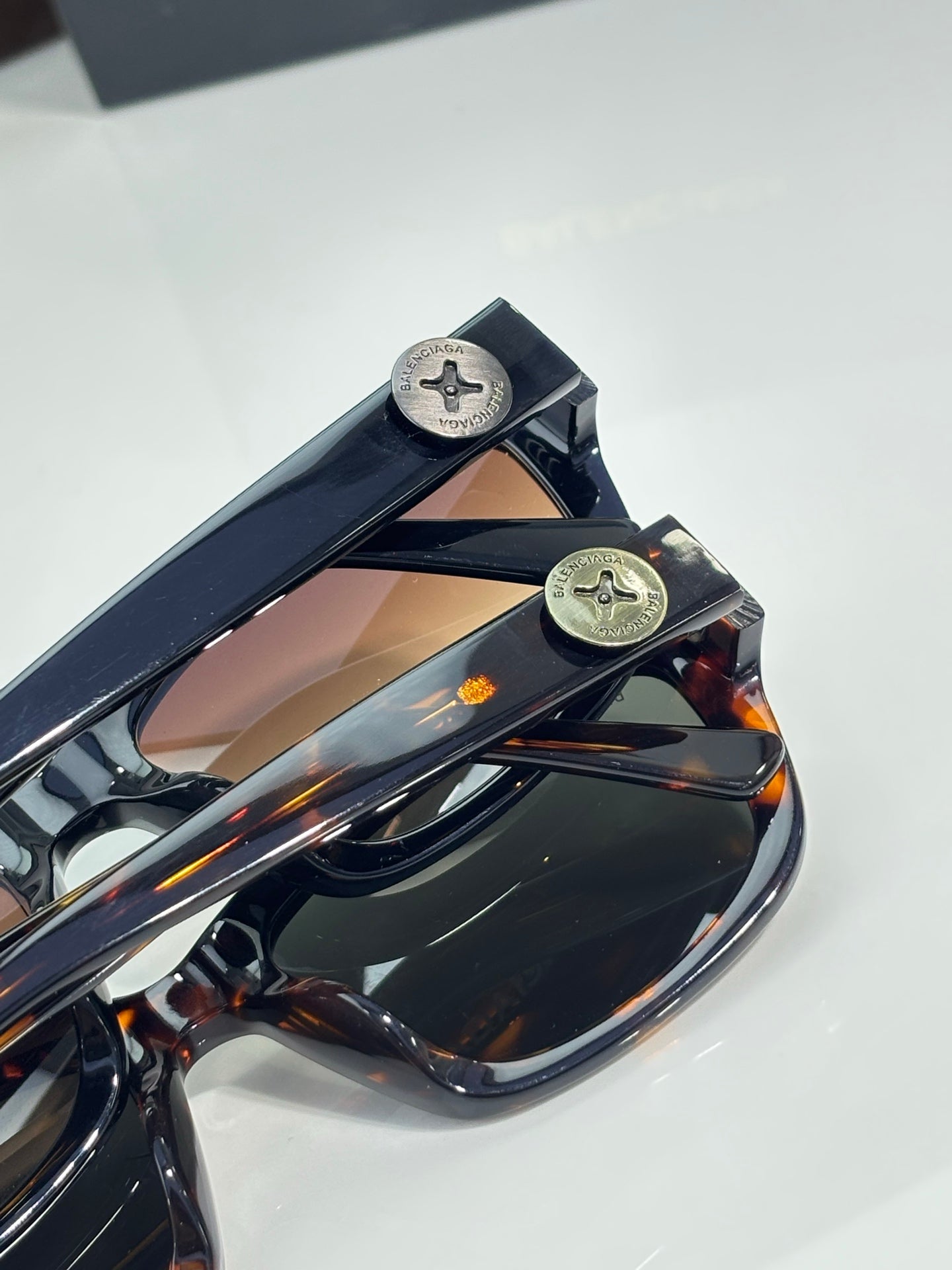 Balenciaga sunglasses hinge and temple detail with logo plates