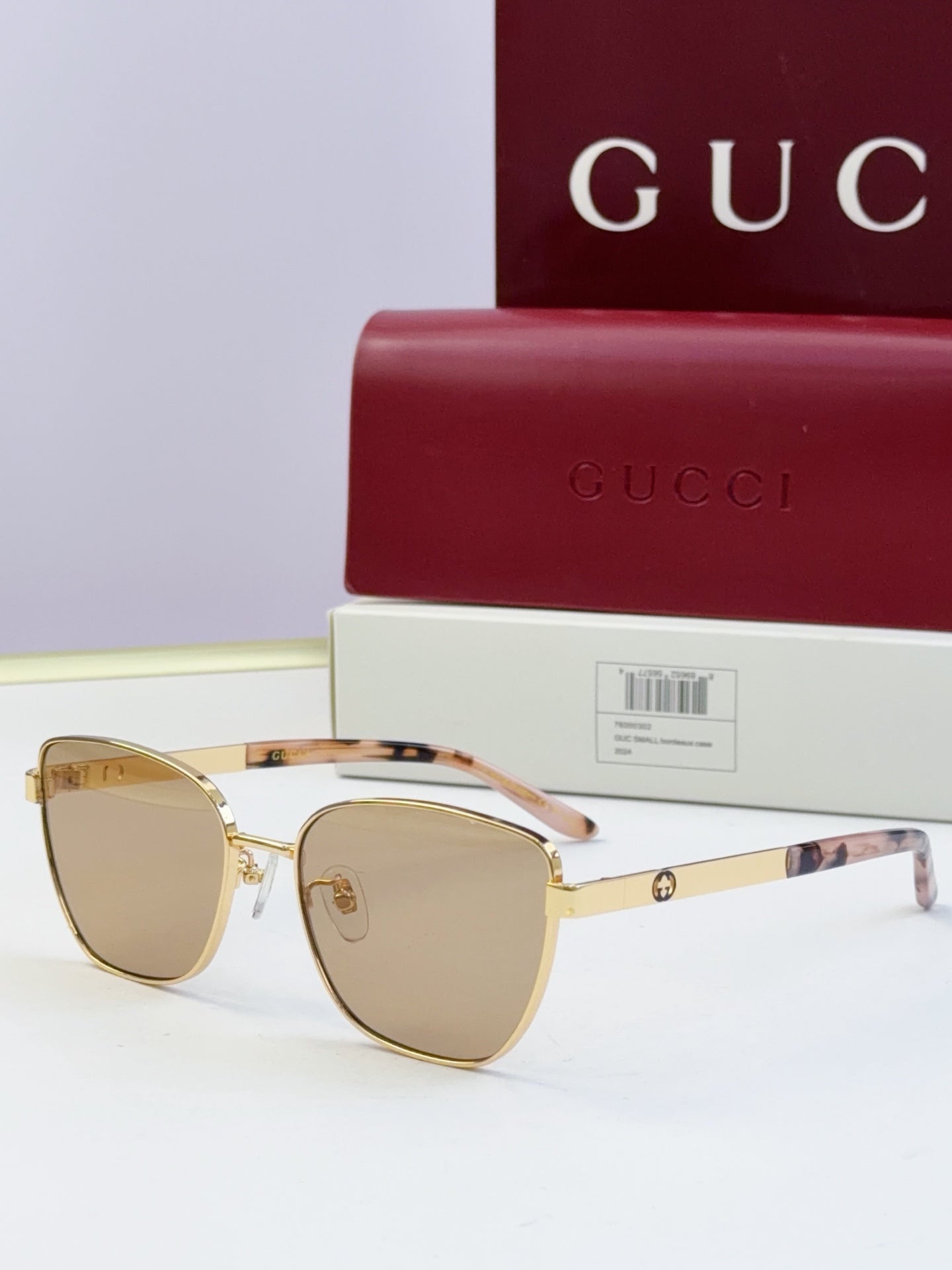 Gucci eyeglasses with gold frames and light-brown lenses; tortoise temples; includes Gucci case.