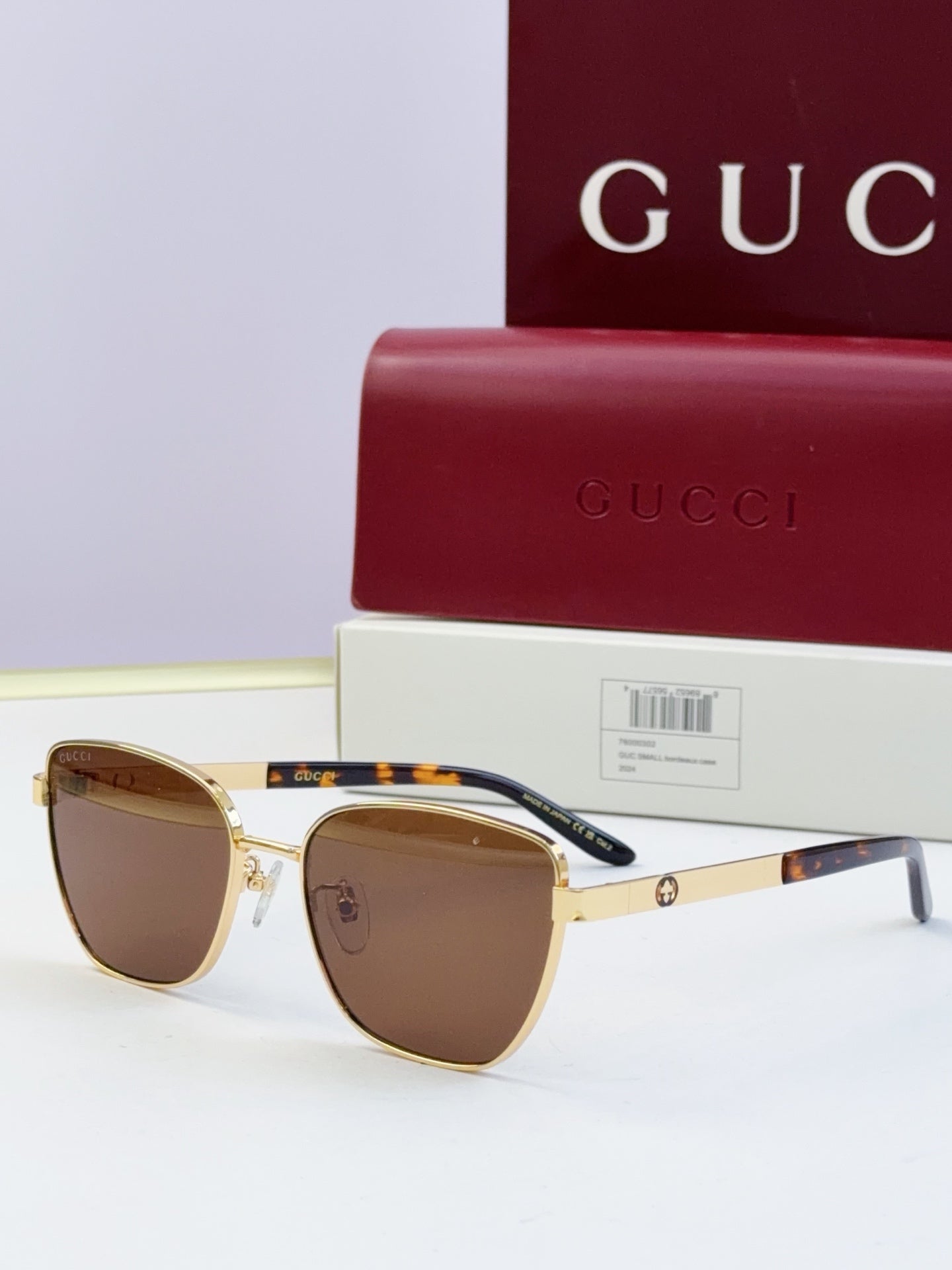 Gucci eyeglasses with gold frames and brown lenses; tortoise temples; includes Gucci case.