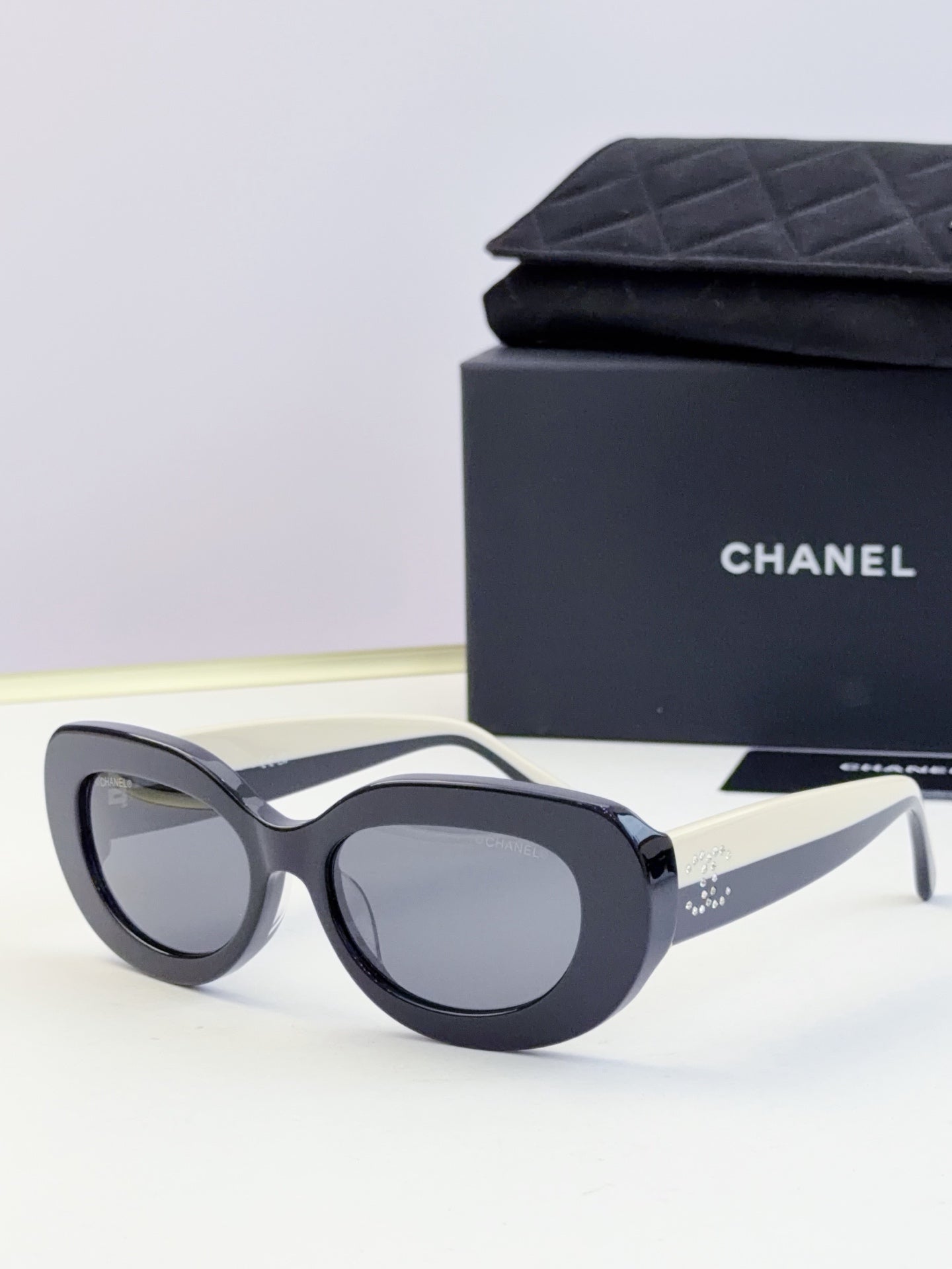 CHANEL sunglasses with dark round lenses and black cat-eye frame