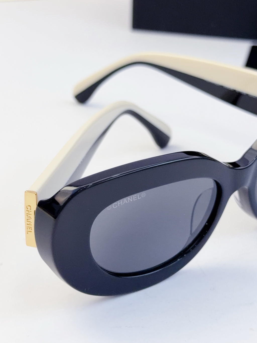CHANEL sunglasses close-up of curved frame and tinted oval lenses