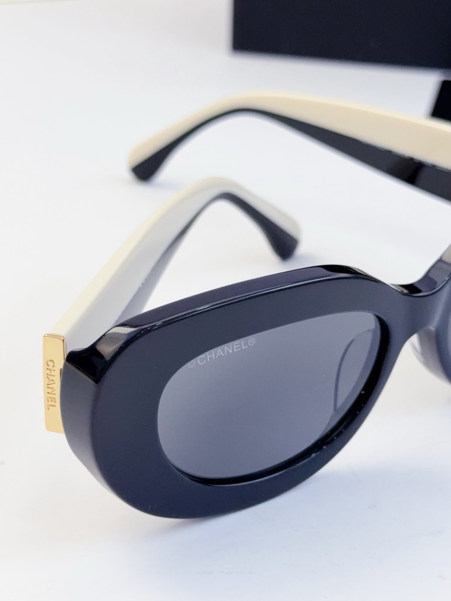 CHANEL sunglasses close-up of curved frame and tinted oval lenses