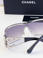 Sunglasses side view with smoky gradient lenses and gold-tone metal frame, CHANEL logo