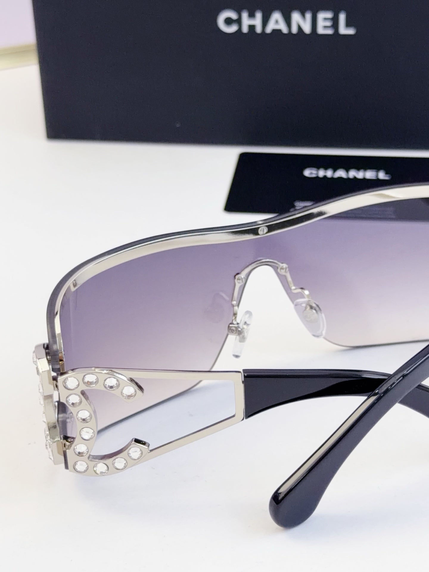 Sunglasses side view with smoky gradient lenses and gold-tone metal frame, CHANEL logo