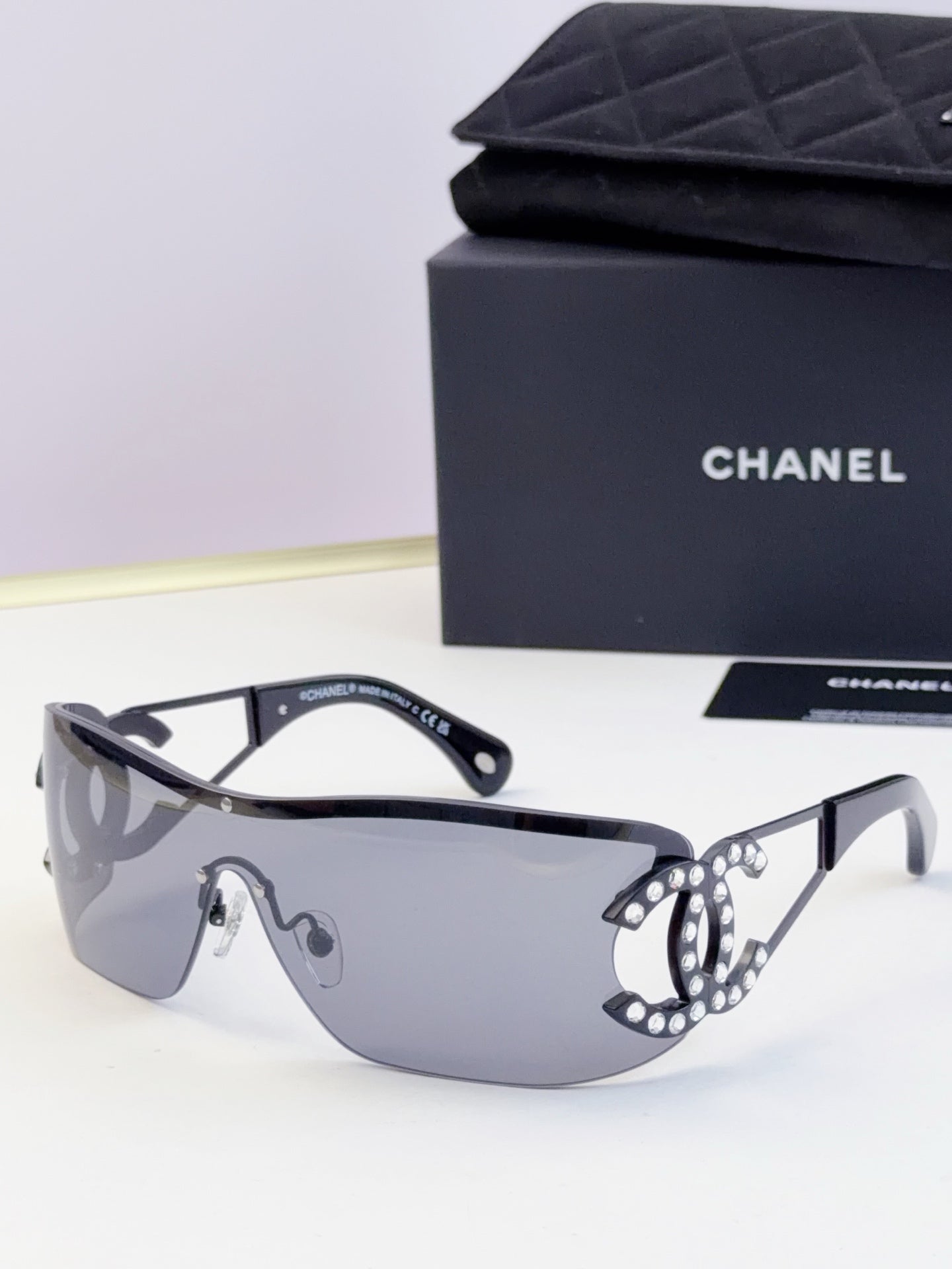 Sunglasses with light gray gradient lenses and navy temple tips, embellished frame detail