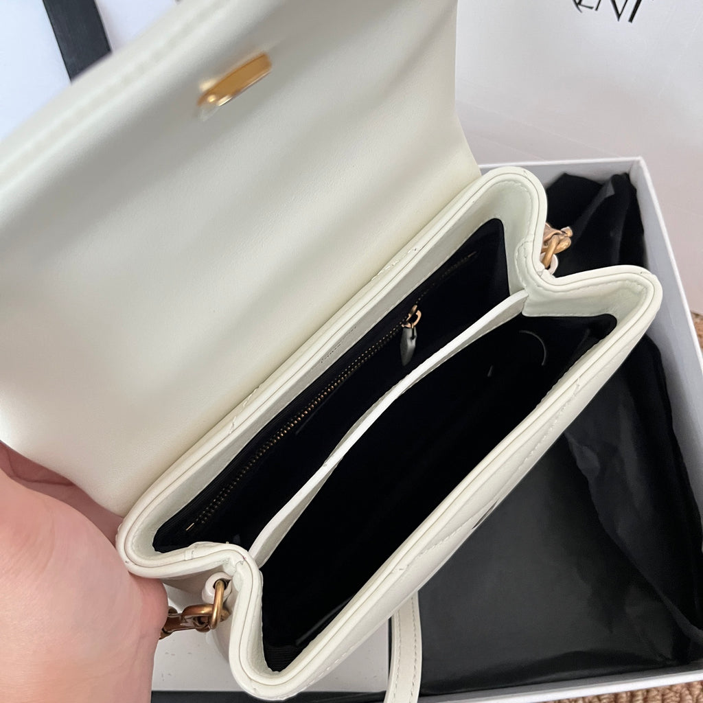 Saint Laurent bag interior with black lining and zipper pocket, light cream exterior