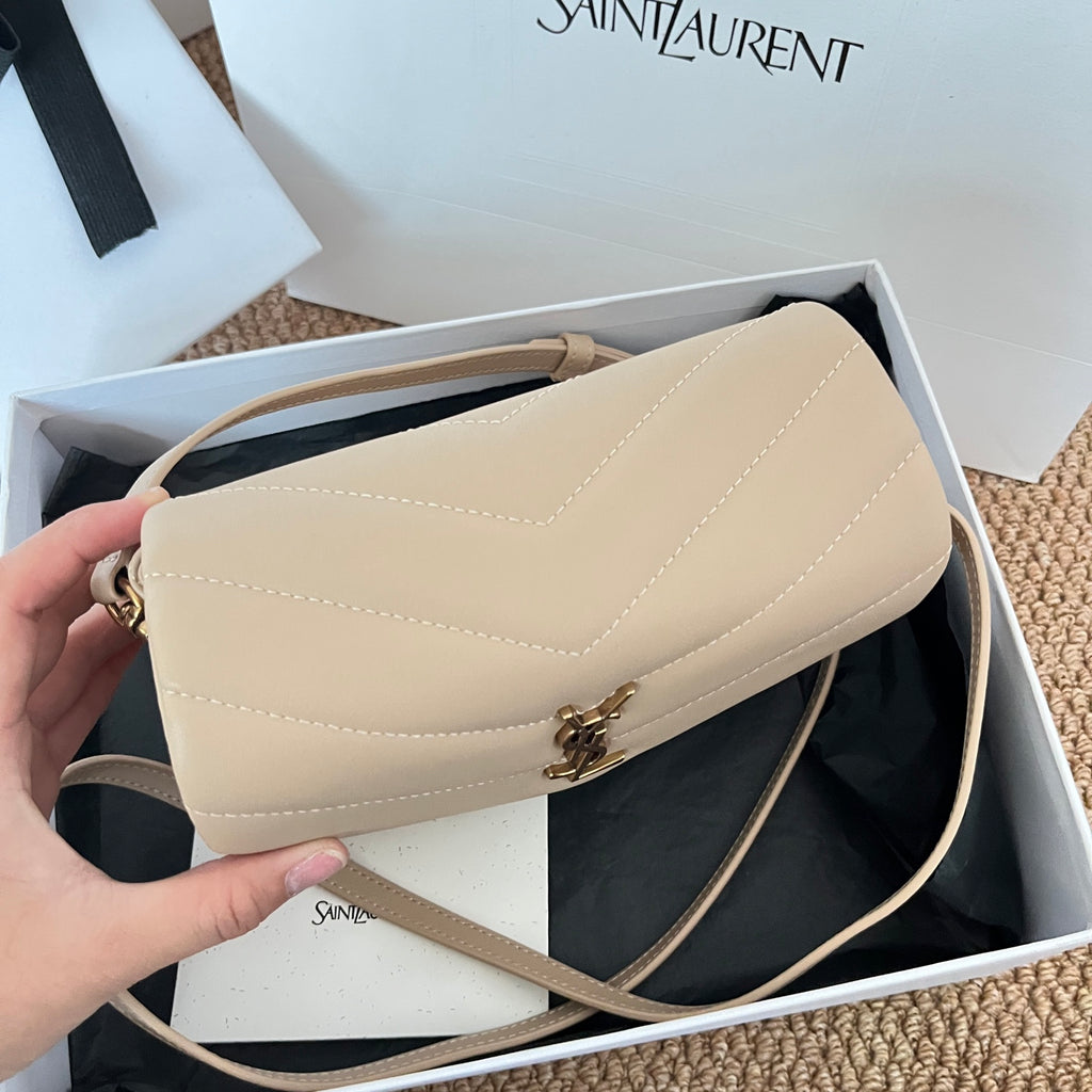 Beige YSL shoulder bag with flap and crossbody strap held in hand
